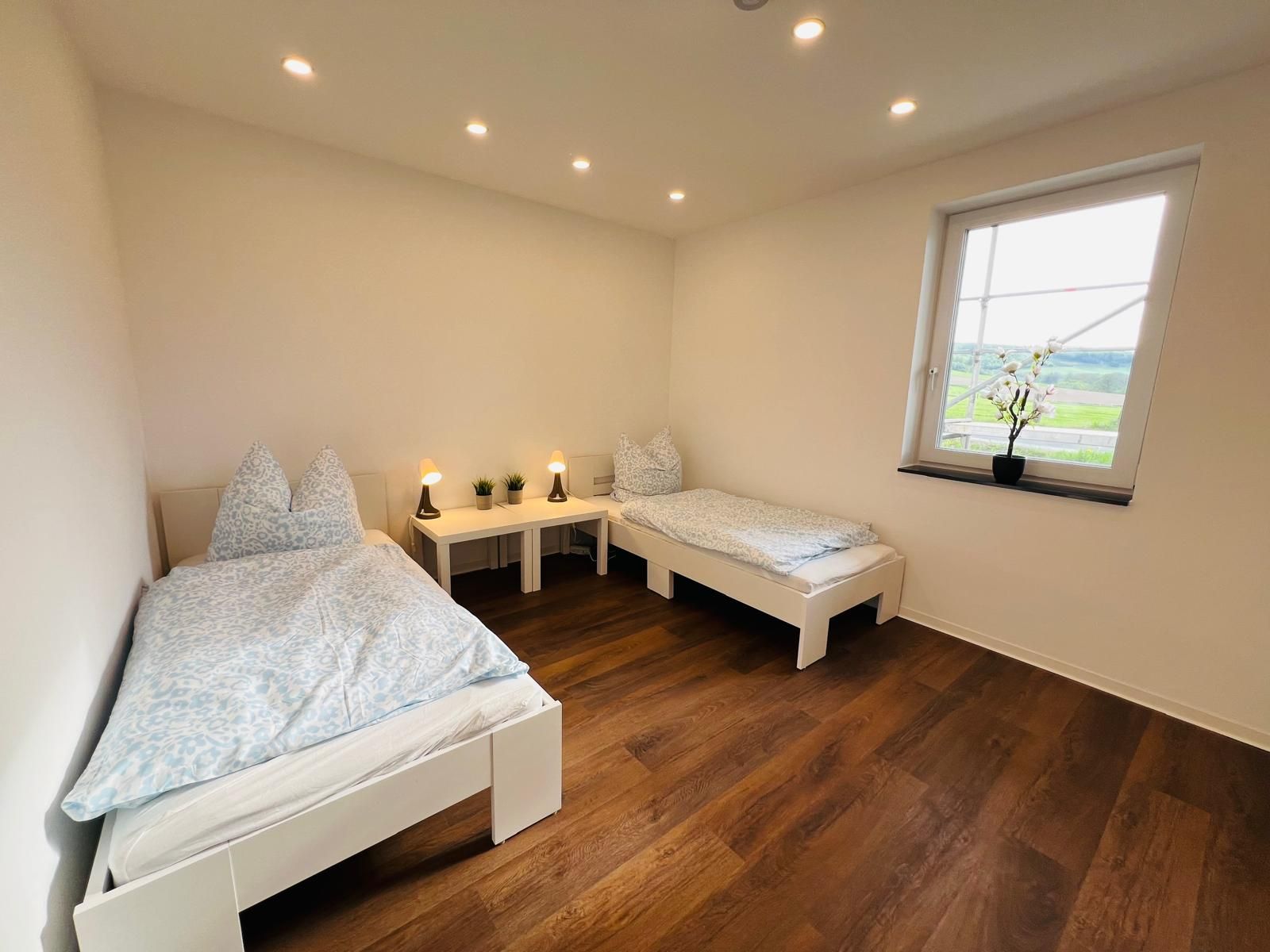 Helles, modernes Zwei-Bett-Zimmer mit gutem Arbeitsplatz, schöner Beleuchtung und makellosem Zustand — sehr ansprechend für Monteure.