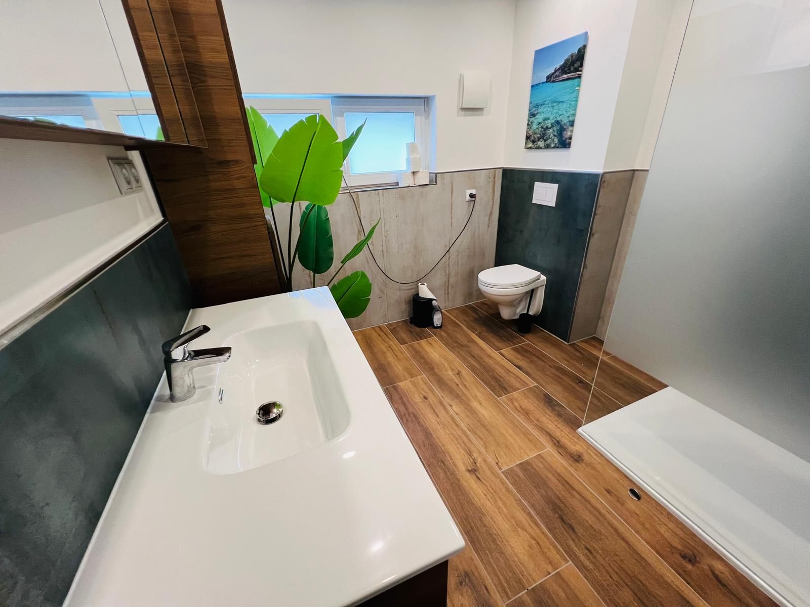 Modernes, großzügiges Bad mit Doppelwaschbecken und bodengleicher Dusche — sauber, hell und sehr funktional.
